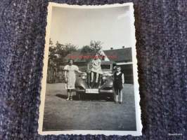 Vanha auto ja äiti lapsineen - valokuva